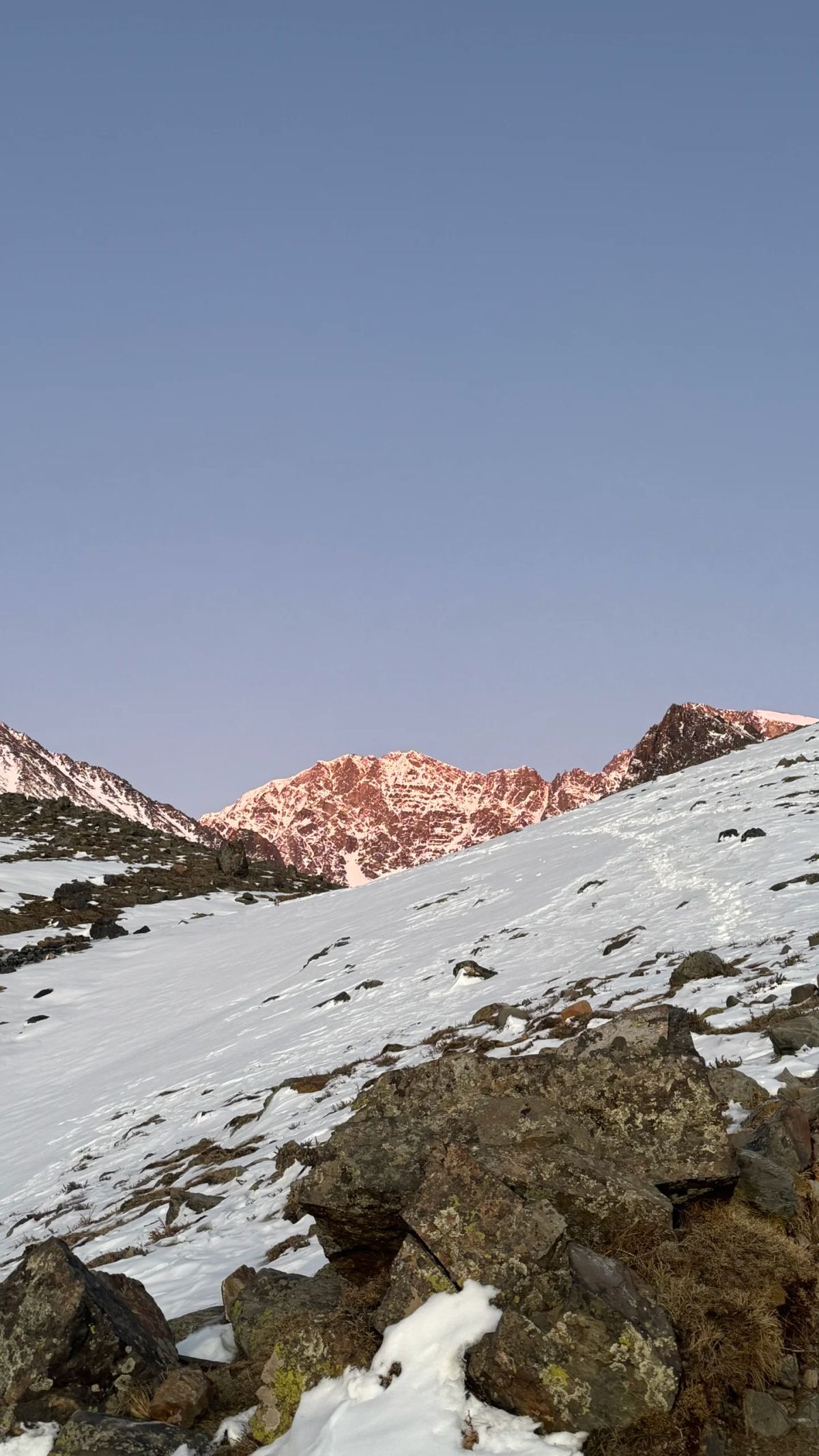 Luz rosada del amanecer sobre las laderas nevadas del Cordón del Plata