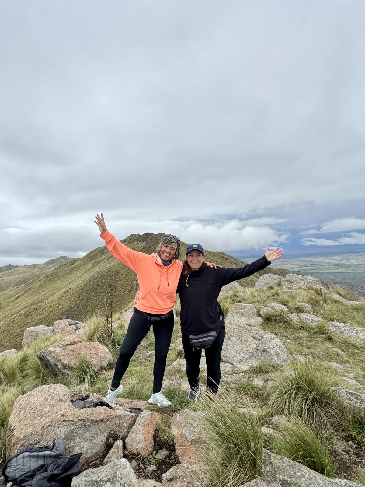 Dos participantes celebrando con los brazos abiertos en el filón del Cerro El Morro