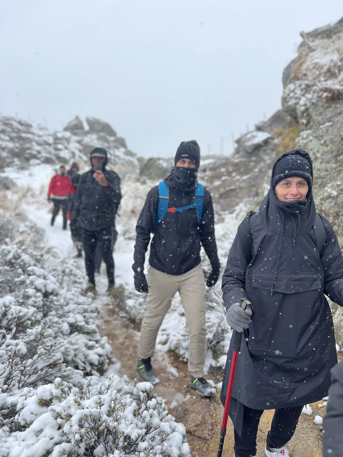 Trekkers abrigados avanzando por el sendero nevado de Los Gigantes