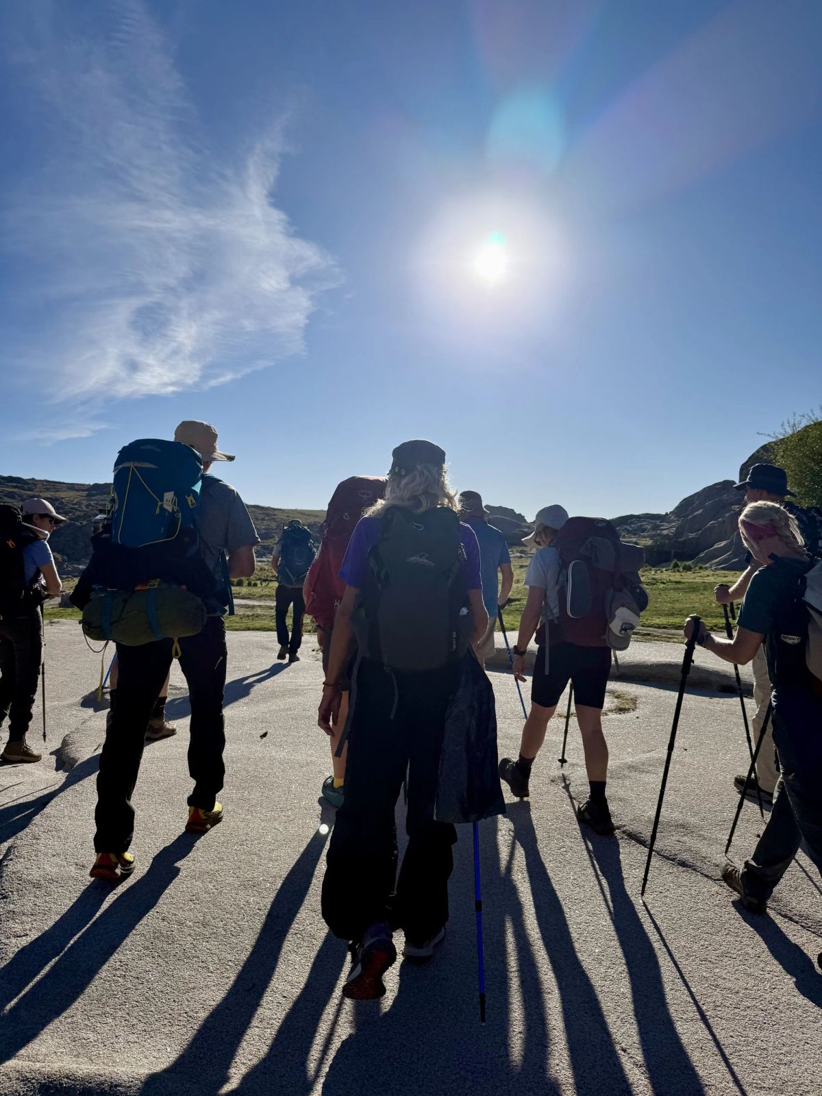 Trekkers a contraluz sobre las lajas de granito durante el descenso del Champaquí