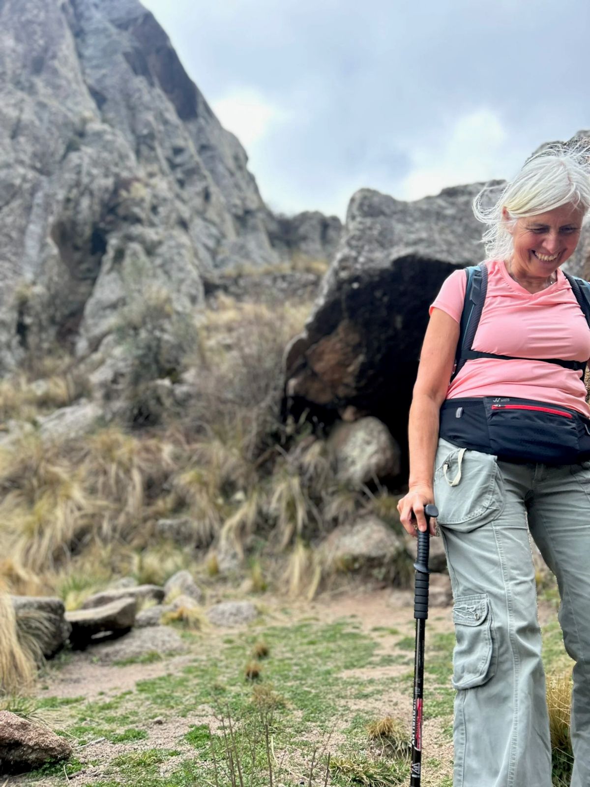 Trekker avanzando con bastones entre pajonales y bloques de granito en Los Gigantes