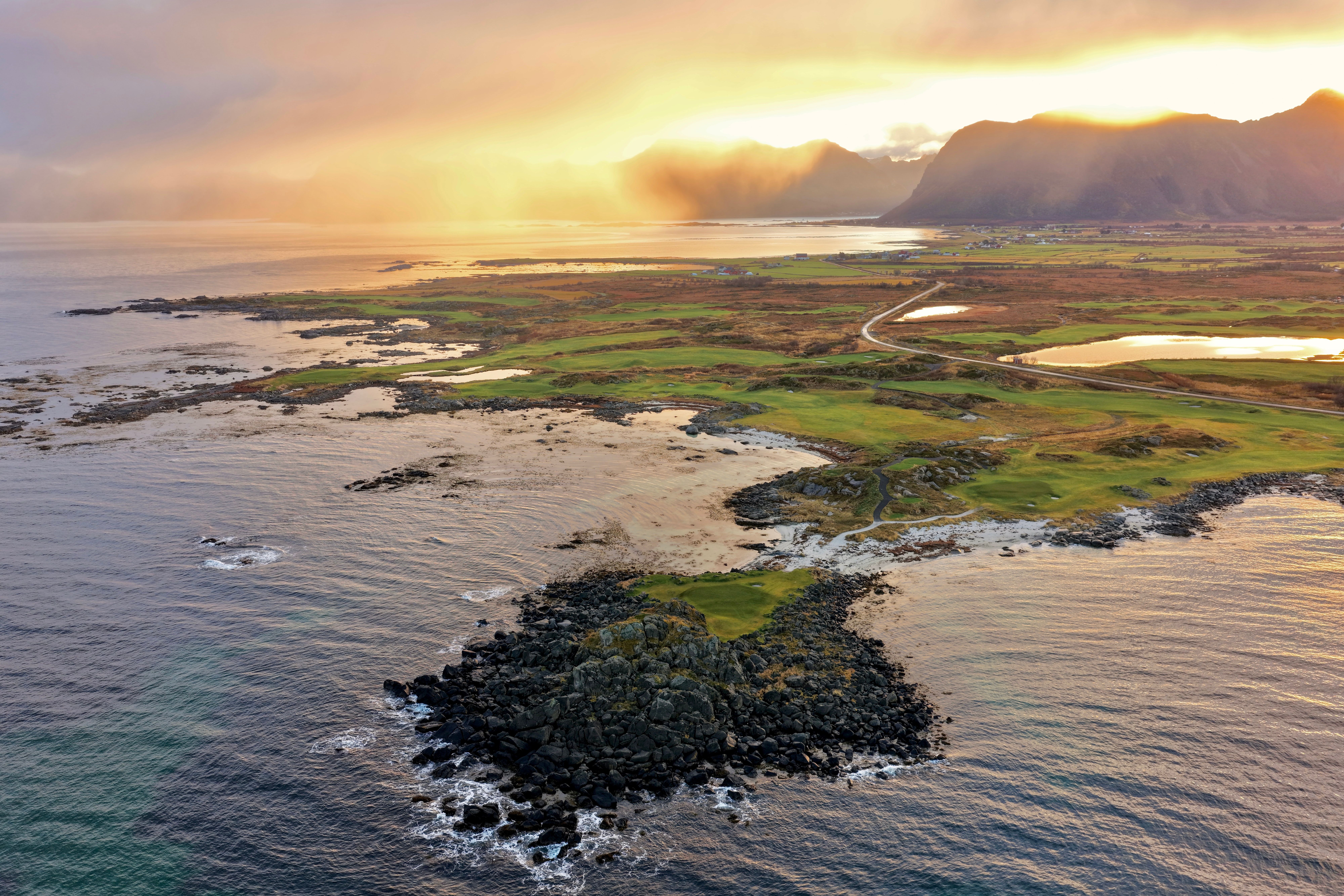 Aerial view of Lofoten Links on a rocky coast at sunset, Norway