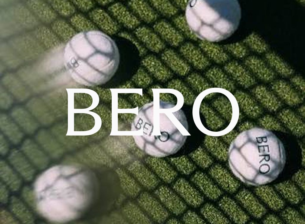 BERO logo over white BERO golf balls on a sunlit grass mat