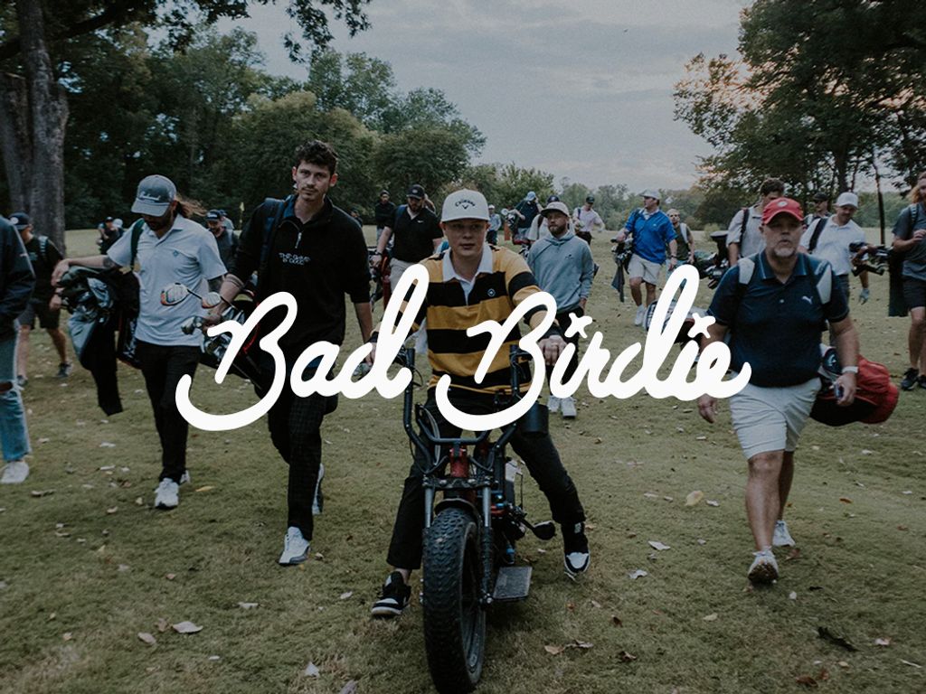 Bad Birdie logo over a golfer on an e-bike leading a crowd across a course