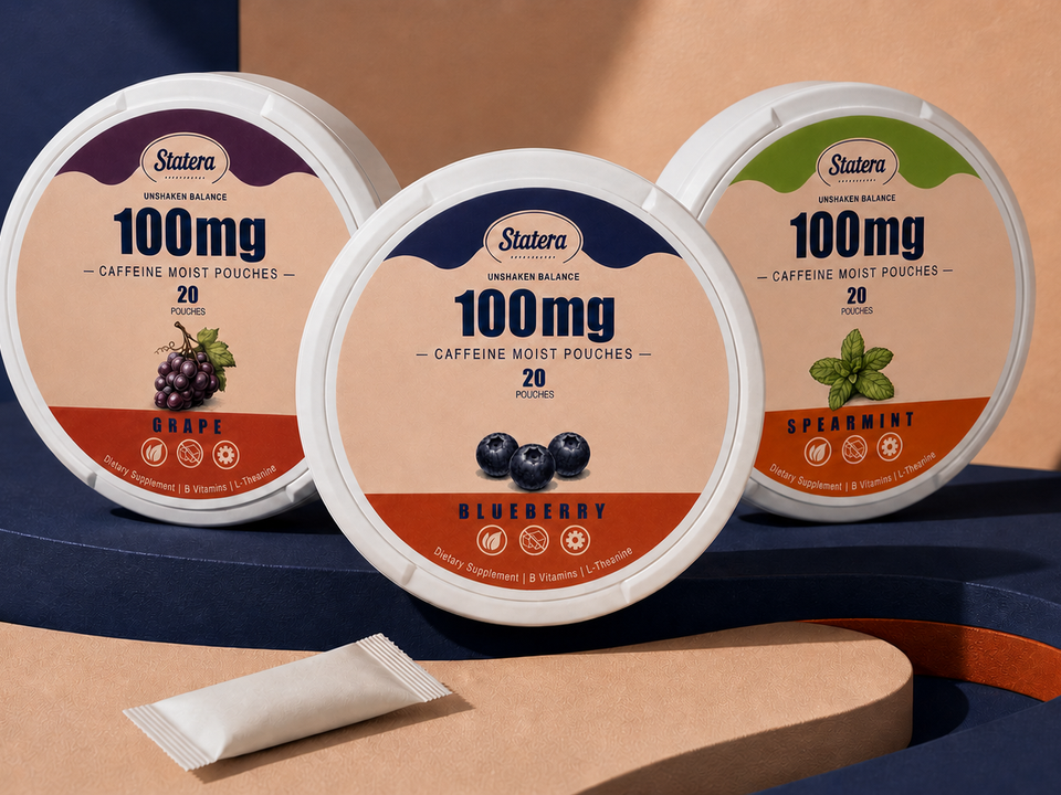 STATERA Grape, Blueberry and Spearmint 100mg caffeine pouch cans with one loose pouch on a sculptural navy and peach editorial set