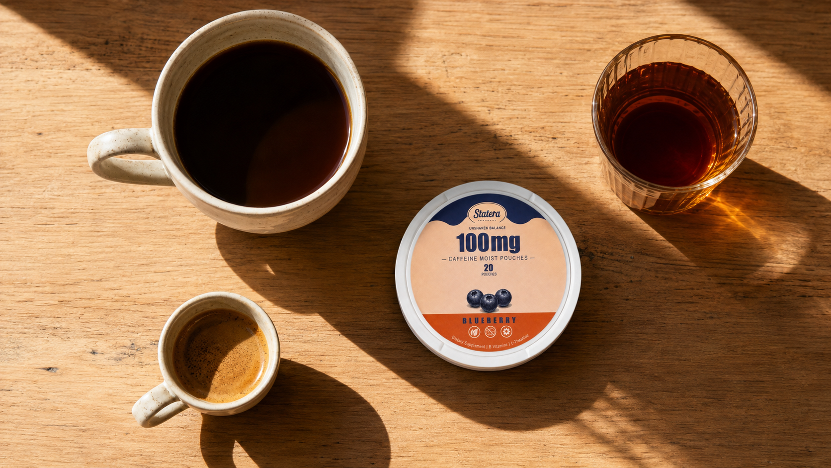 STATERA Blueberry 100mg can with filter coffee, espresso and black tea on a sunlit wooden table