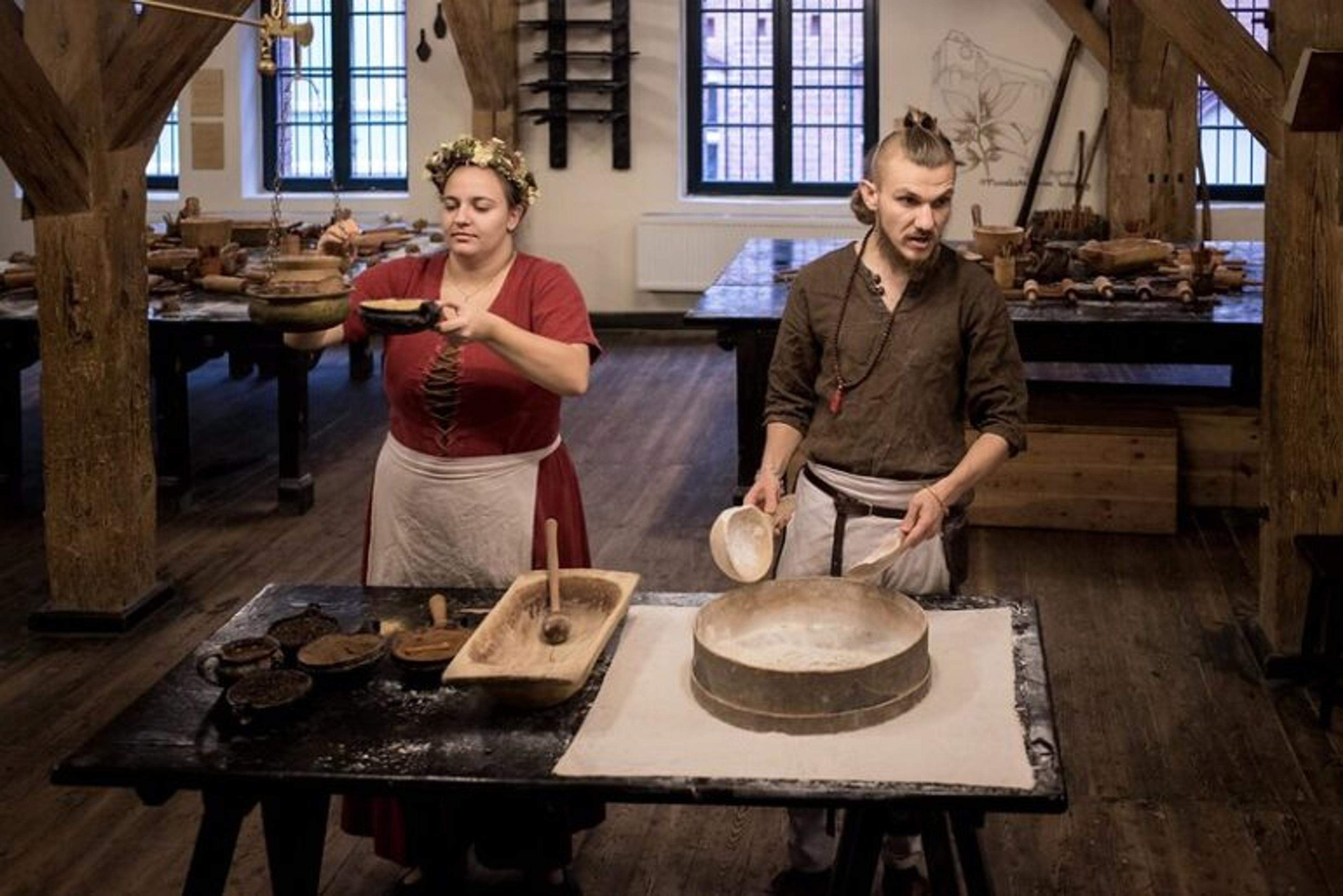 Kobieta i mężczyzna przygotowują ciasto na pierniki w drewnianym pomieszczeniu