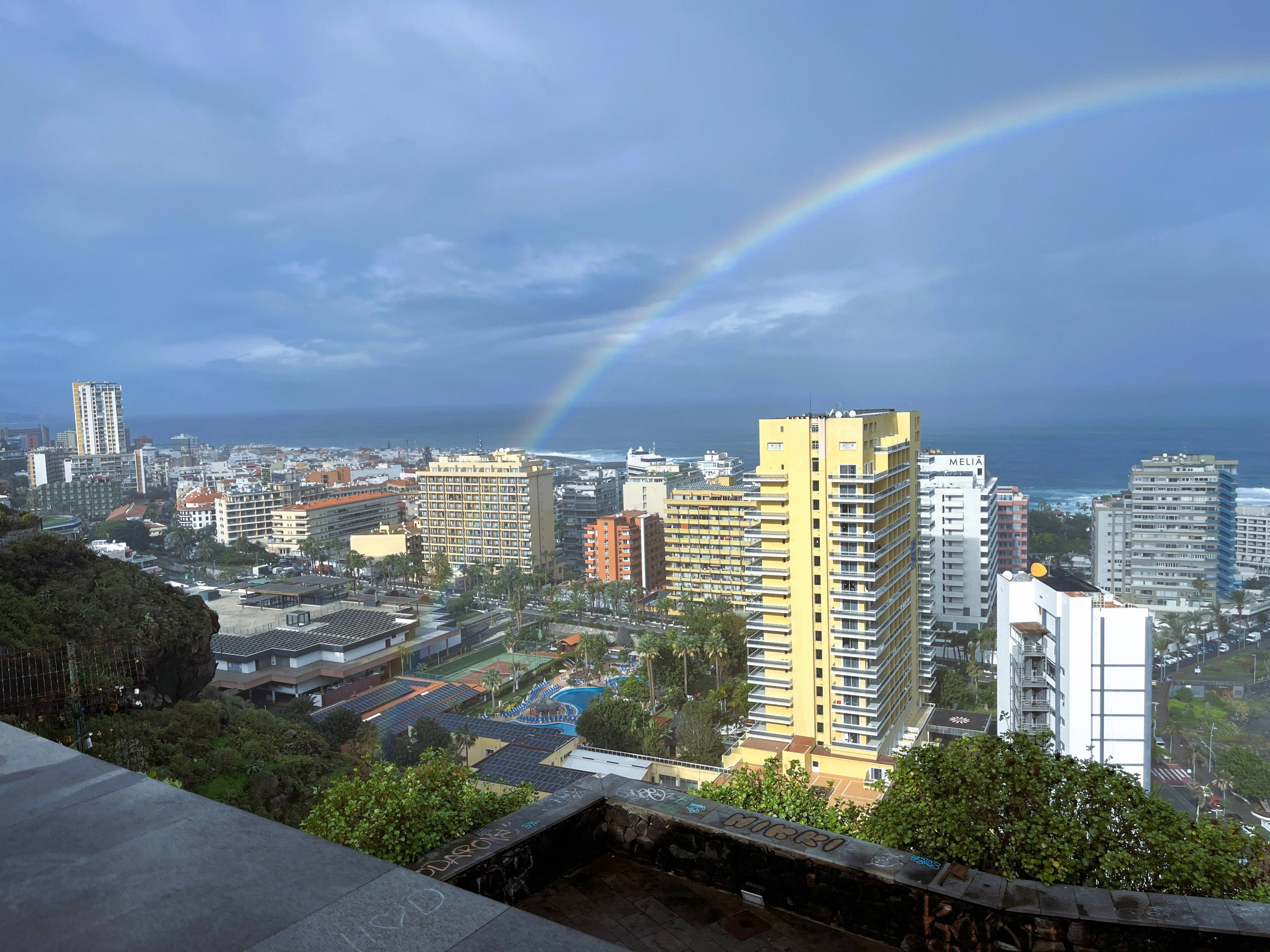 Widok miasta z wysokimi budynkami i oceanem w oddali.