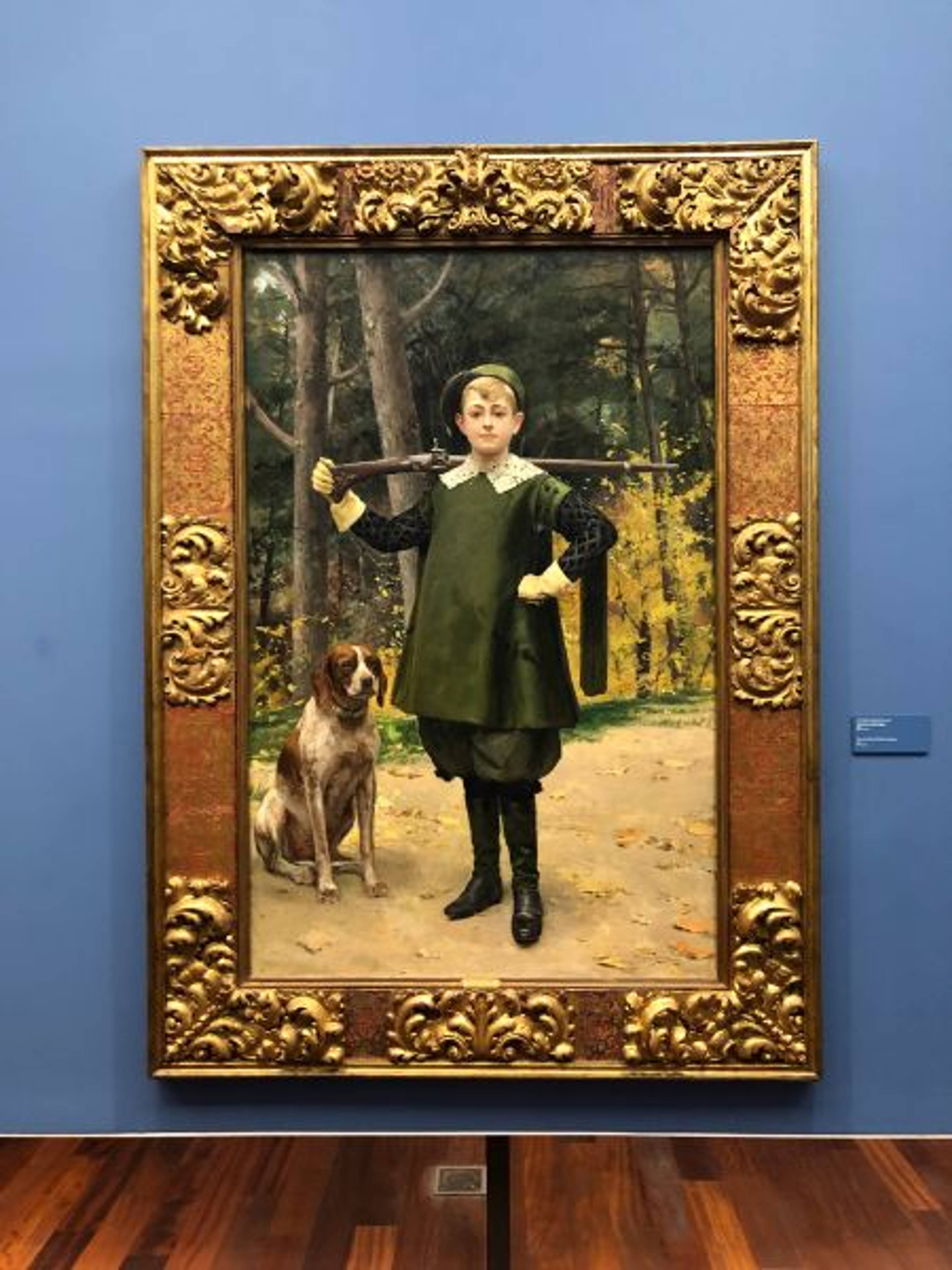 Obraz przedstawiający chłopca w stroju do polowania z bronią i psem