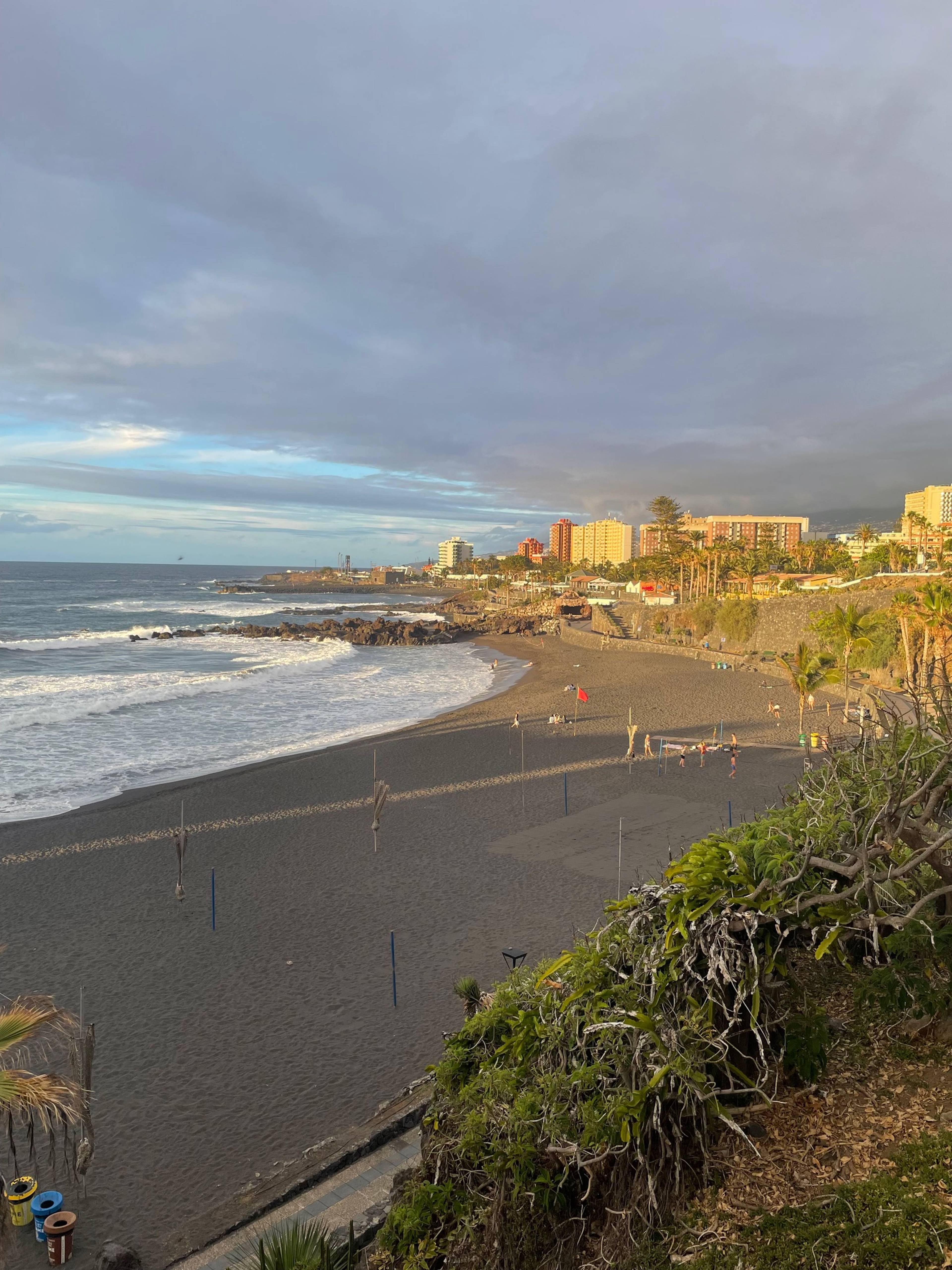 Piaszczysta plaża i ocean widziane z punktu widokowego o zachodzie słońca.