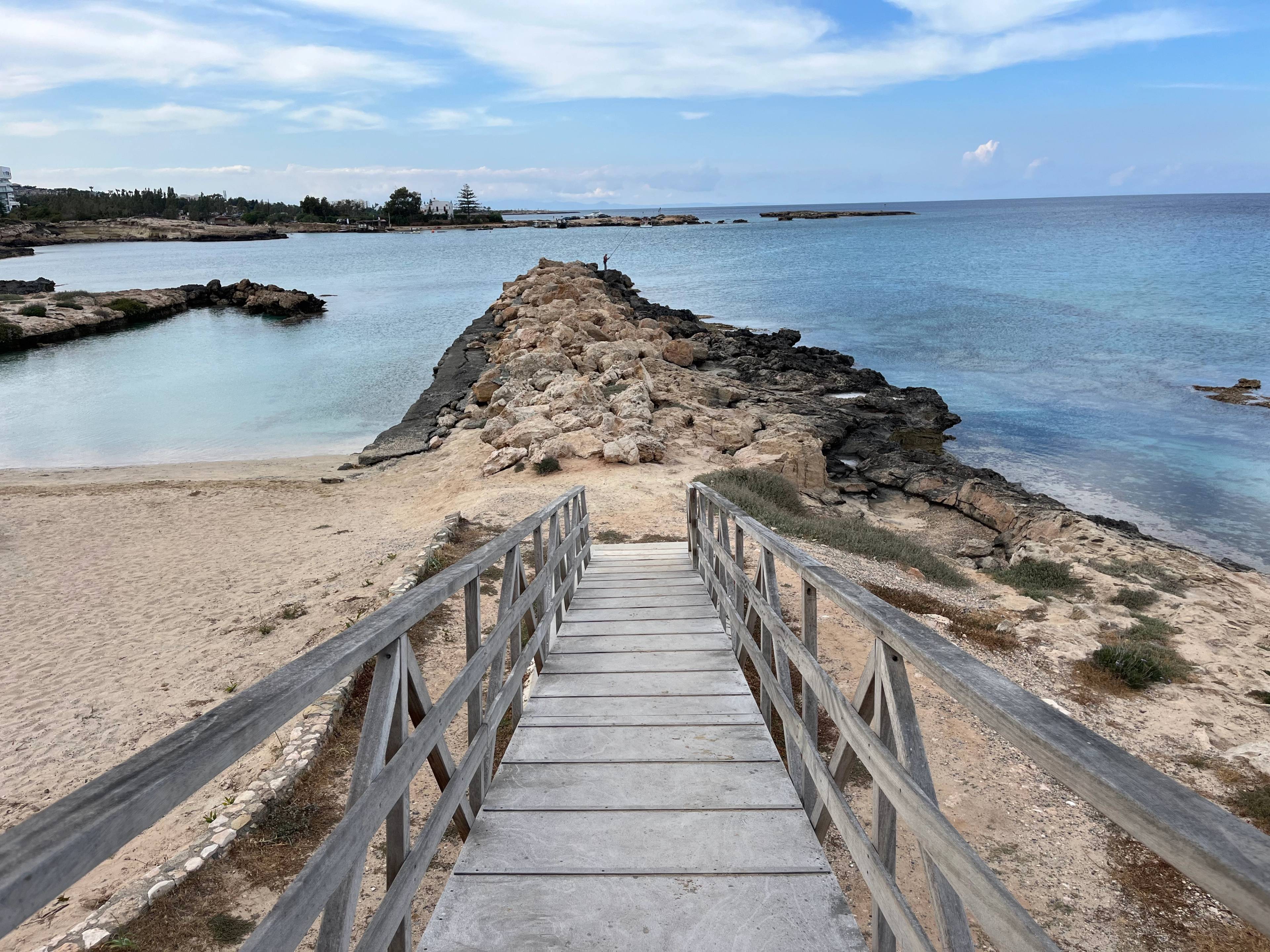 Drewniany pomost prowadzący na skaliste wybrzeże - plaża Glyfades w Protaras na Cyprze.