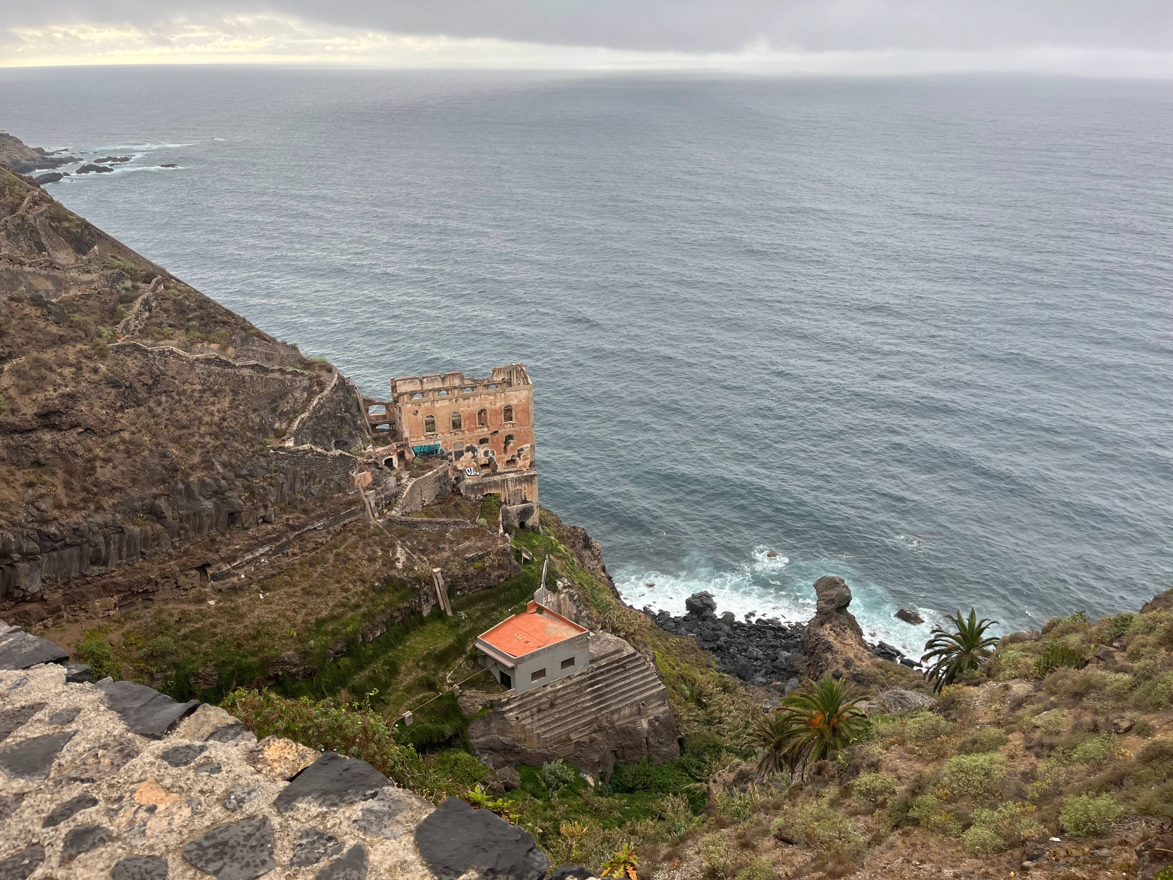Ruiny dawnej pompowni wody na skraju stromej góry, w tle morze