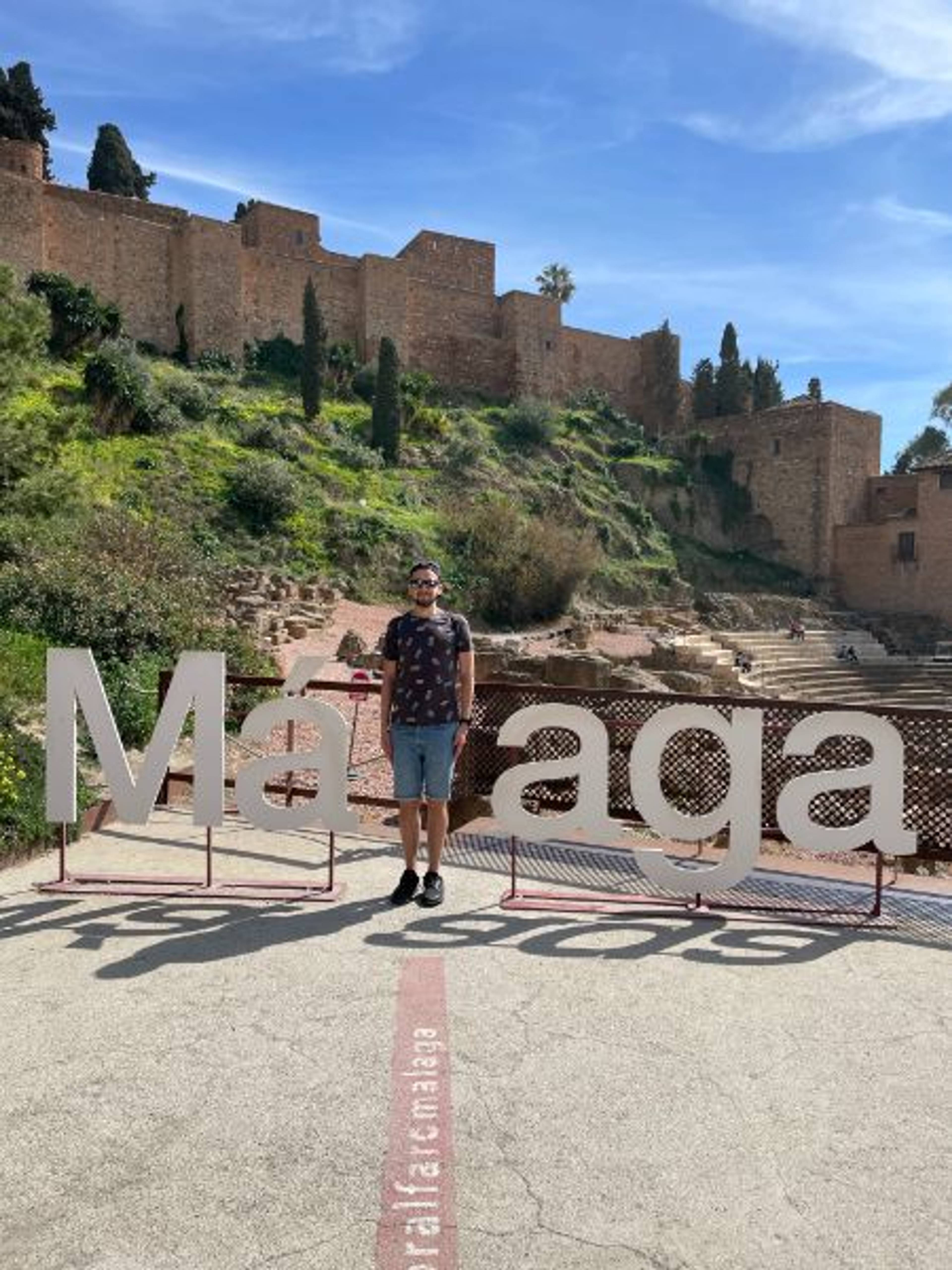Napis Malaga i ruiny Alcazaby w tle