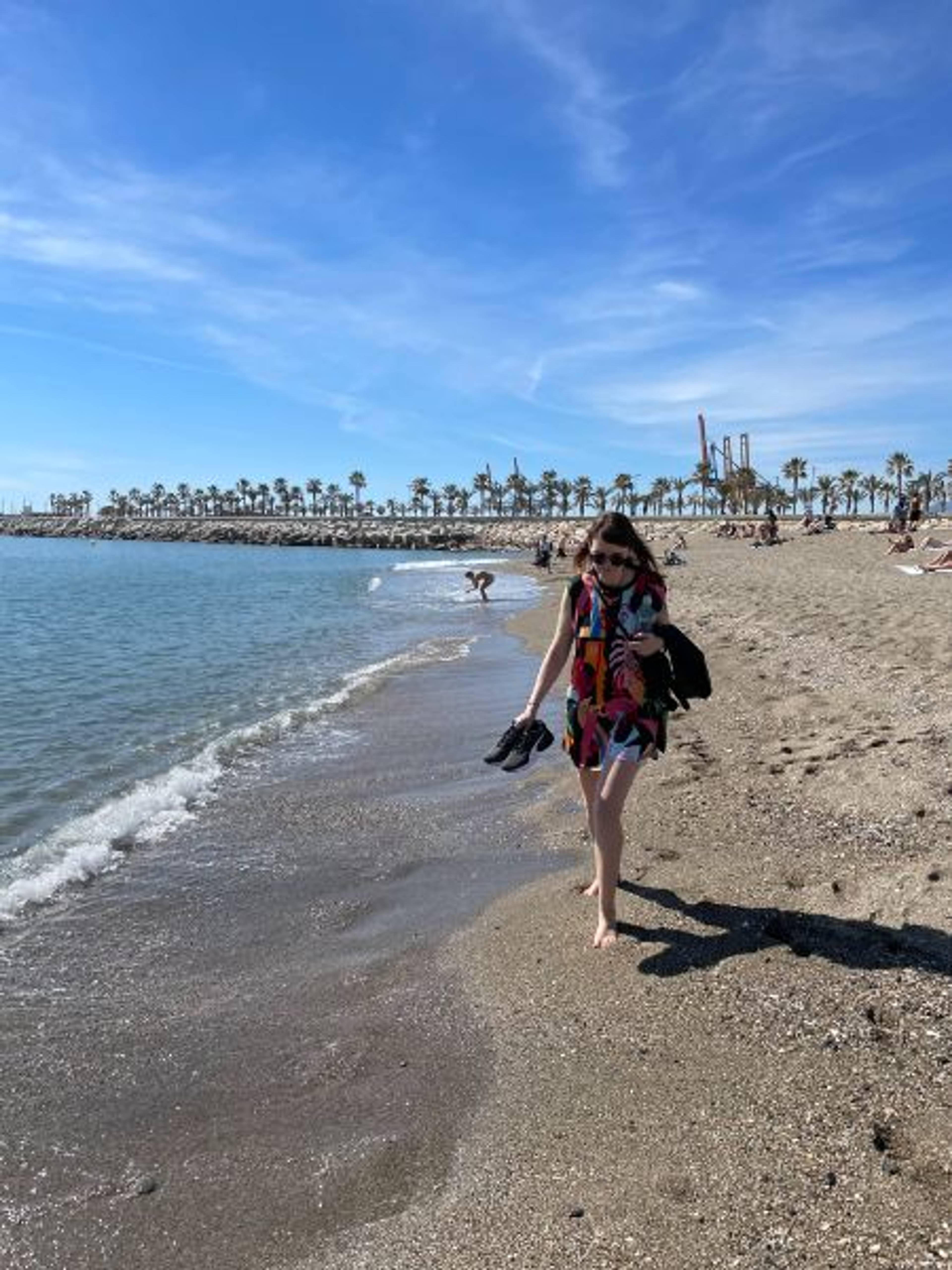 Dziewczyna idąca wzdłuż wybrzeża piaskiem przy morzu