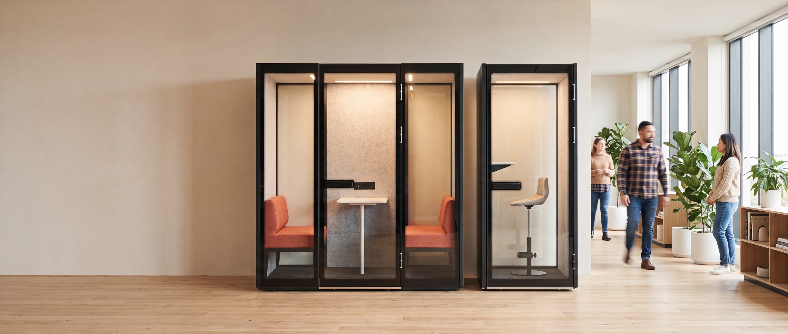 A Peacepod meeting pod and a phone booth installed side by side in a bright open-plan office