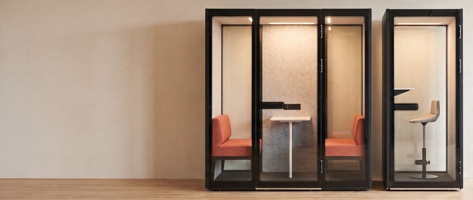A Peacepod meeting pod and a phone booth installed side by side in a bright open-plan office