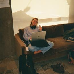 person sitting on a couch with a laptop