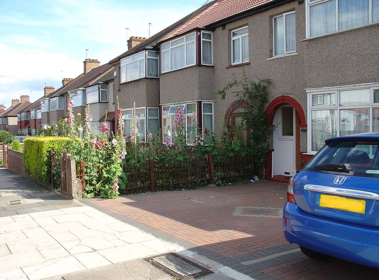 Bricked front garden next to one with flowers