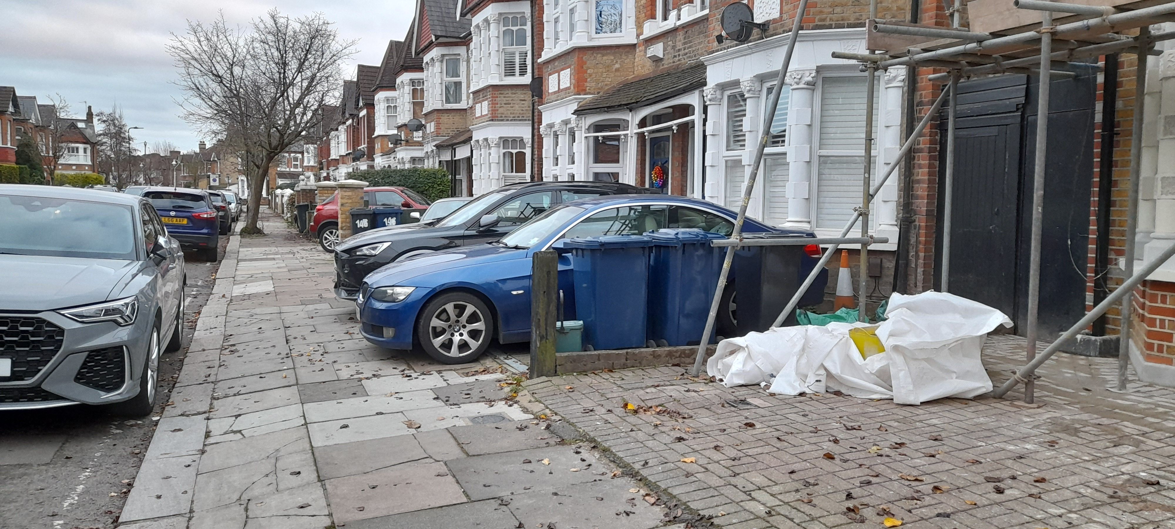 Street with cars parked in front  gardens and no room for street trees