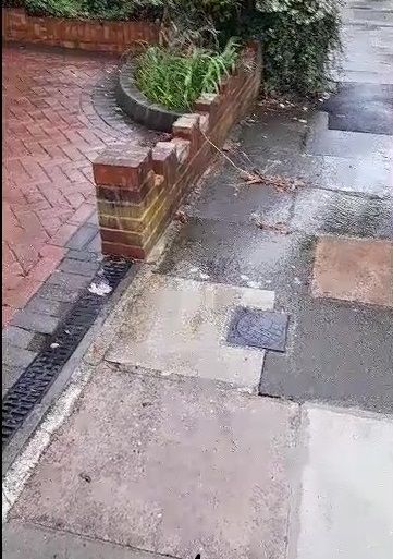 rain running over grille onto pavement 