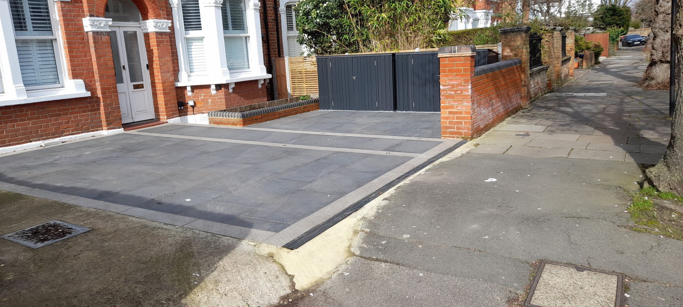 A fully paved front garden next to a concreted one.