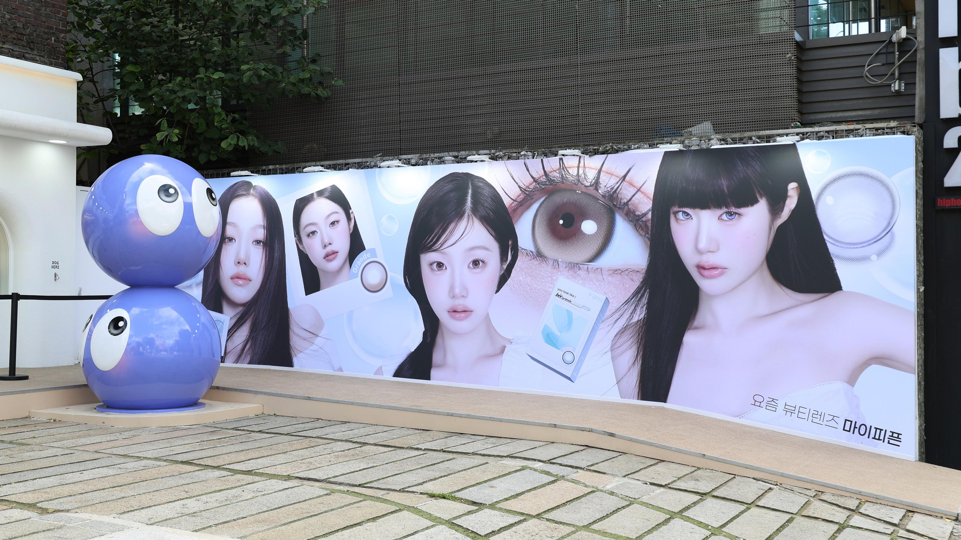 마이피픈 페스타 홍대 팝업 외부 — 렌즈 캐릭터 조형물과 캠페인 키비주얼 월