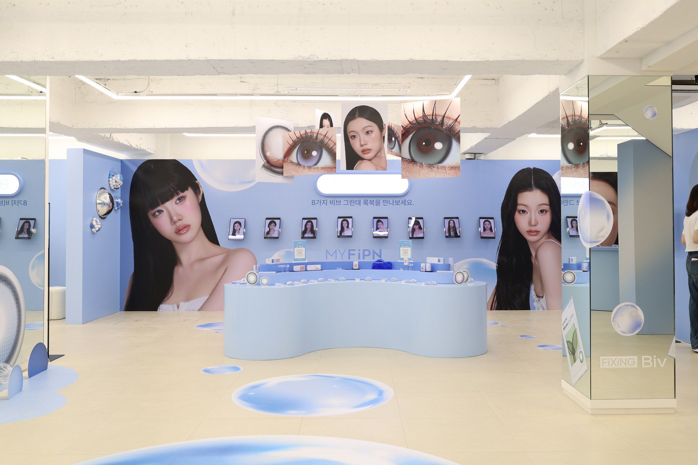 메인 카운터와 캠페인 키비주얼 월, 벽면의 렌즈 진열 선반