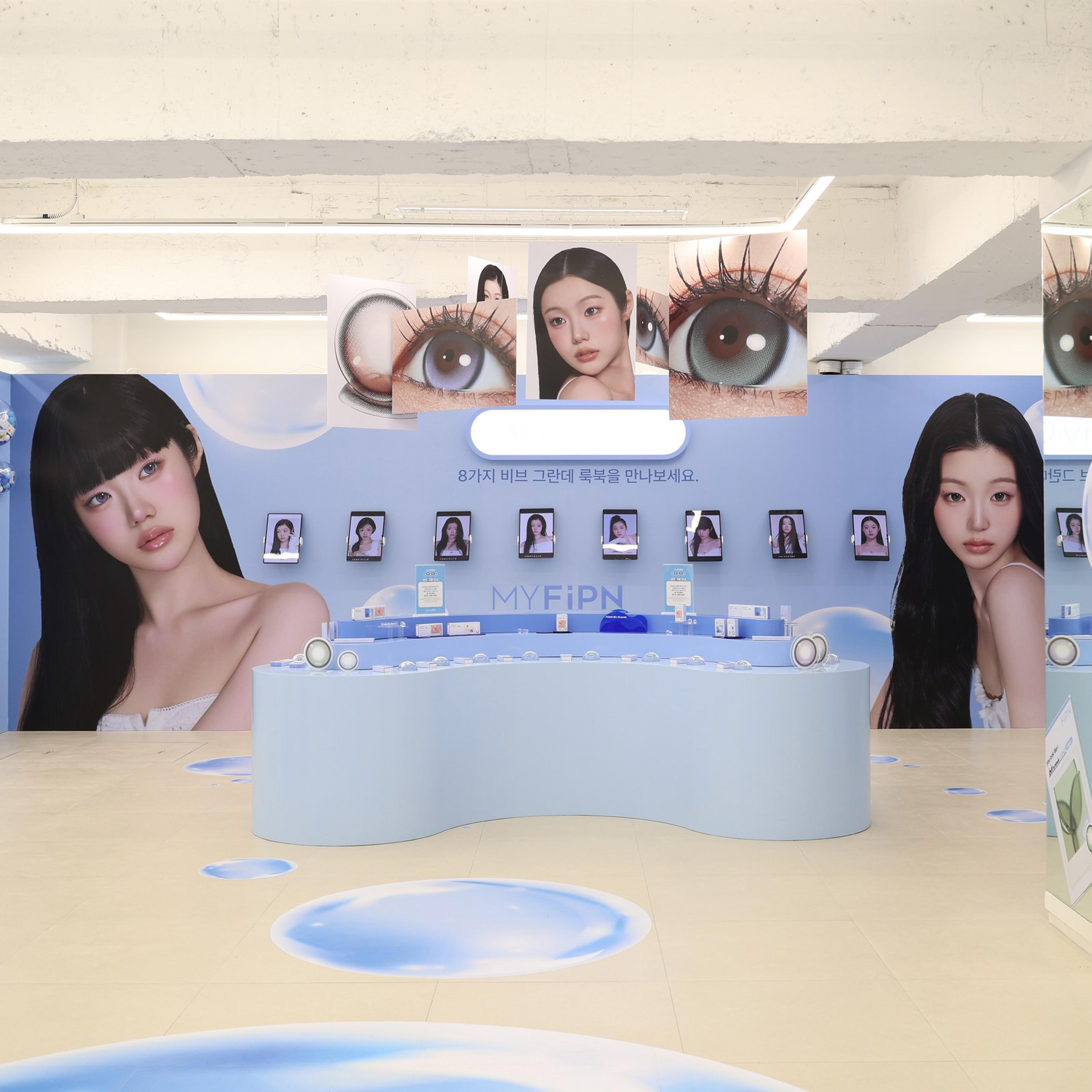 메인 카운터와 캠페인 키비주얼 월, 벽면의 렌즈 진열 선반