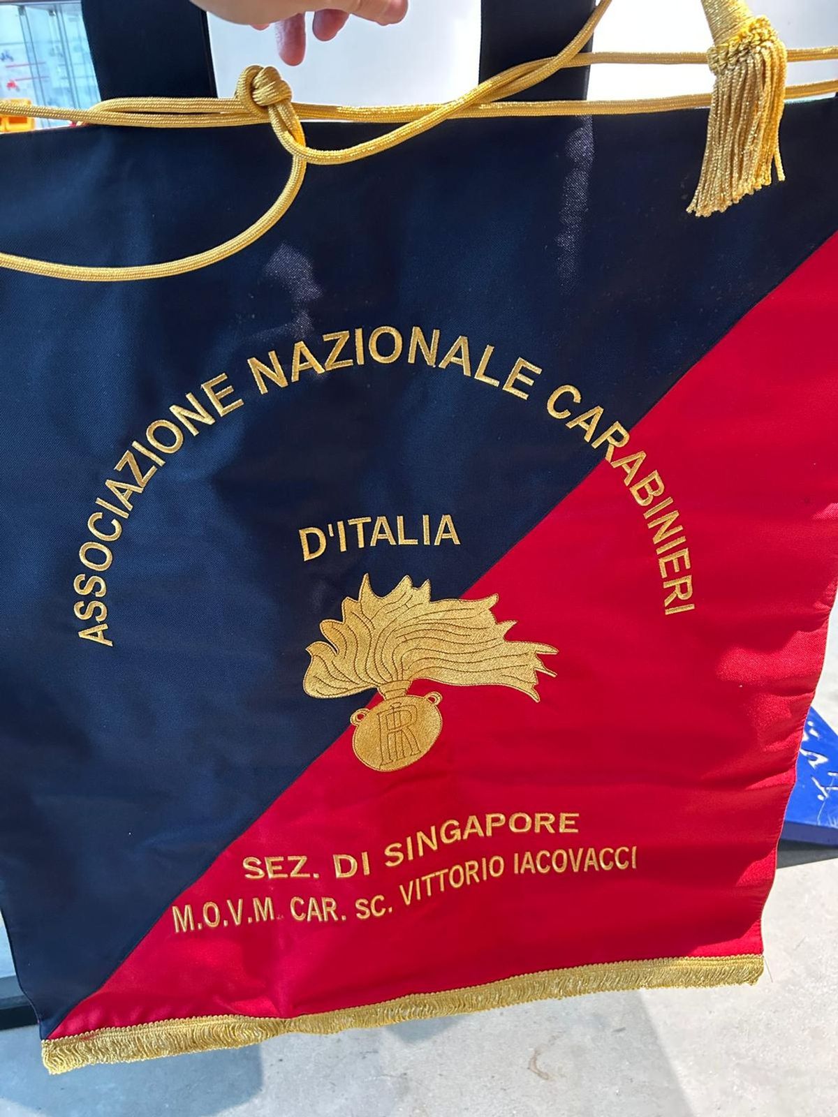 Close-up of the ANC Singapore section banner, embroidered with the name of Vittorio Iacovacci.