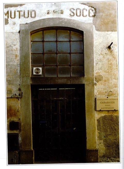Old doorway under the painted words Mutuo Soccorso, with an ANC section plaque beside it.