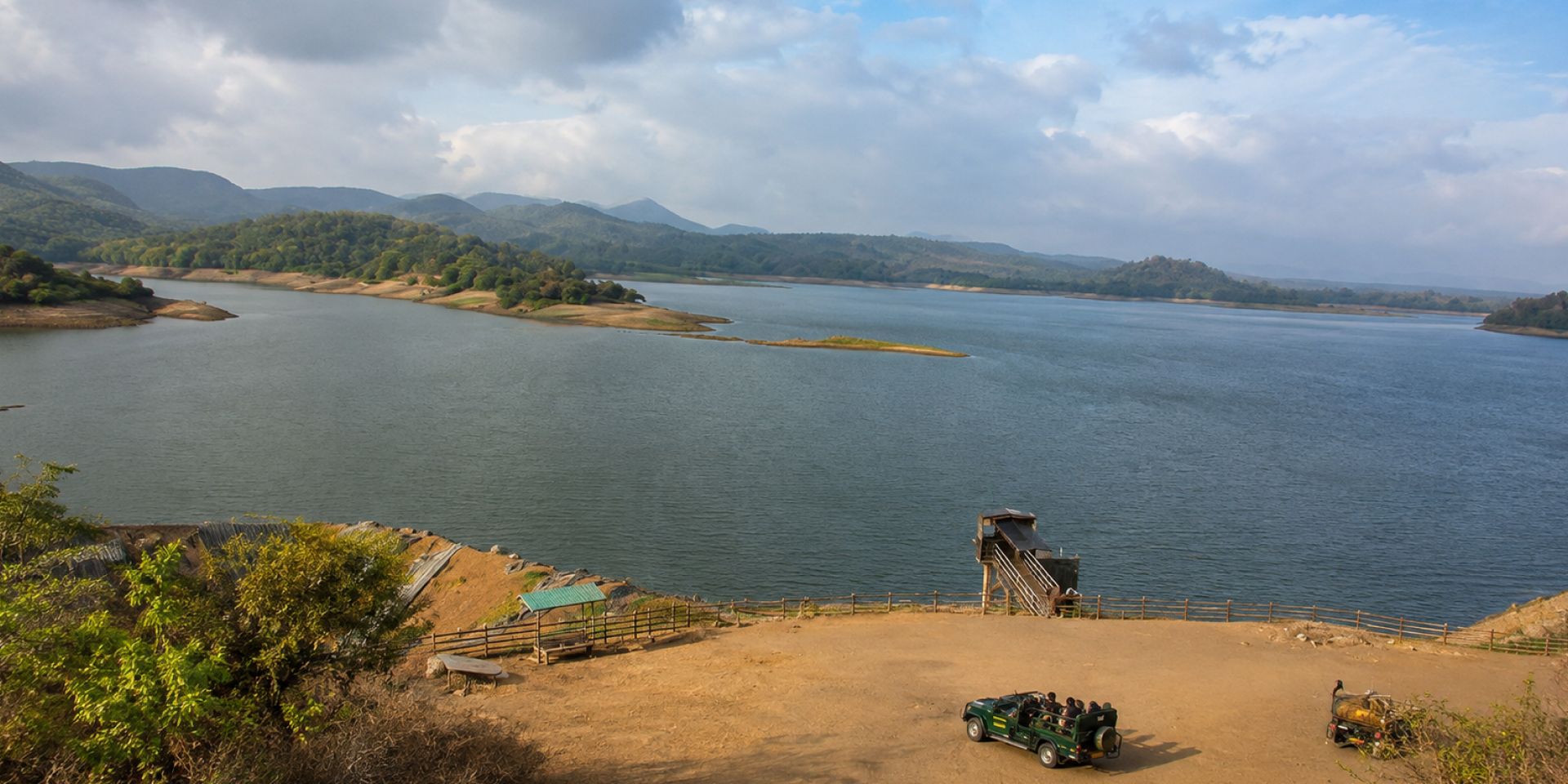 The serene waters of Kamleshwar Dam reservoir surrounded by forested hills inside Gir Sanctuary