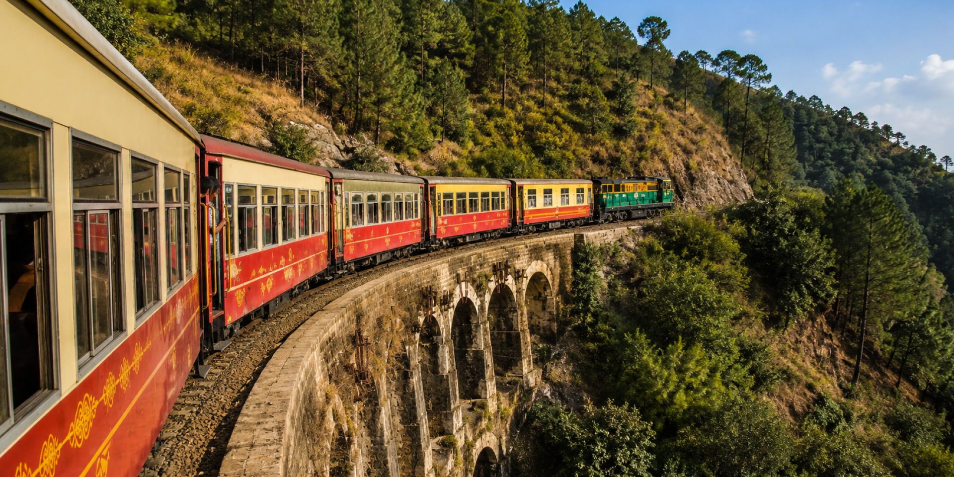 UNESCO World Heritage Kalka-Shimla Toy Train crossing a stone arch bridge