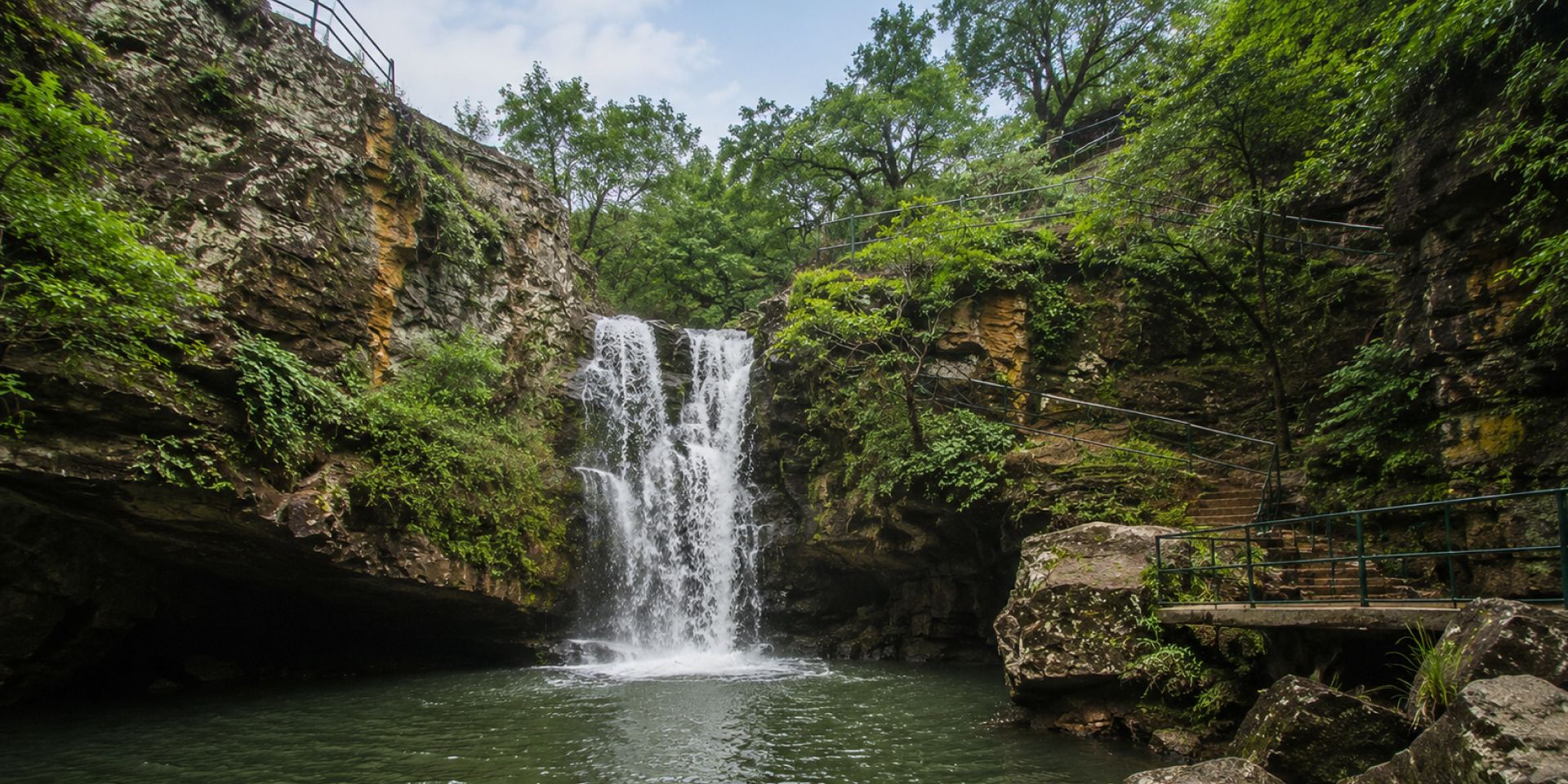 Cascading waters of Bee Fall tumbling down sandstone rocks into forest pool in Pachmarhi