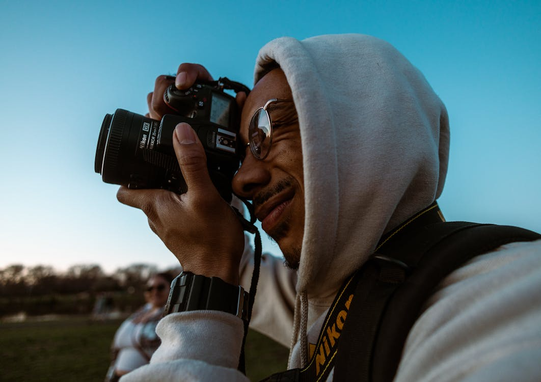 Harvey Specter taking a photo with a Nikon camera