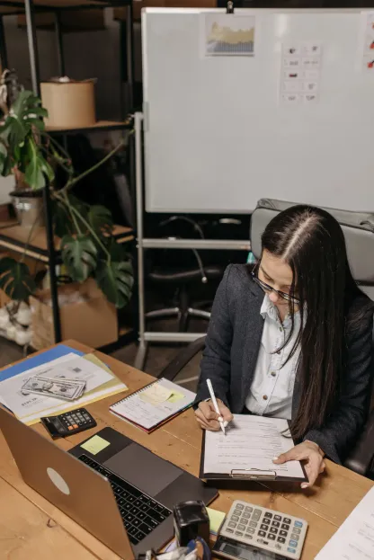 A business professional reviewing paperwork at a desk.