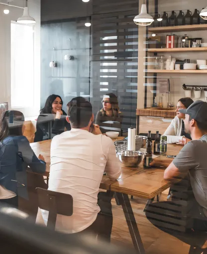 Colleagues discussing their work around a meeting table.