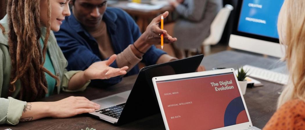 A small agency team reviewing a website design on a laptop during a project meeting