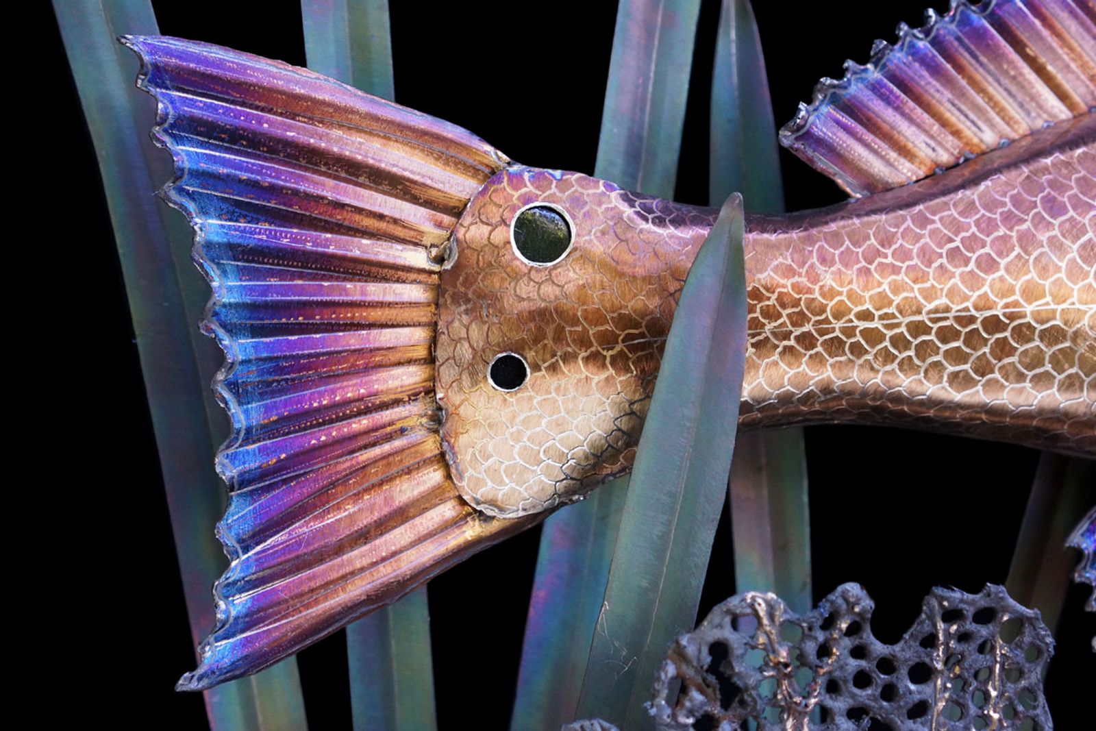 Closeup of metal red drum sculpture's tail.