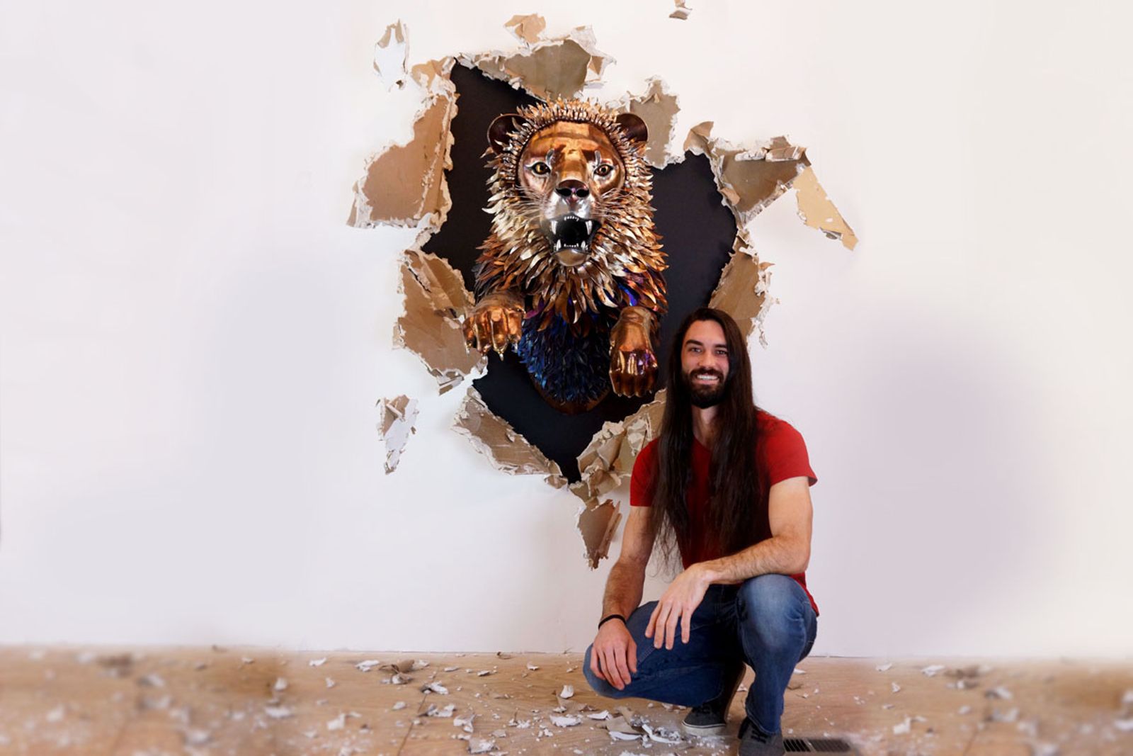 Artist Aiden Dale with his metal lion sculpture for scale.