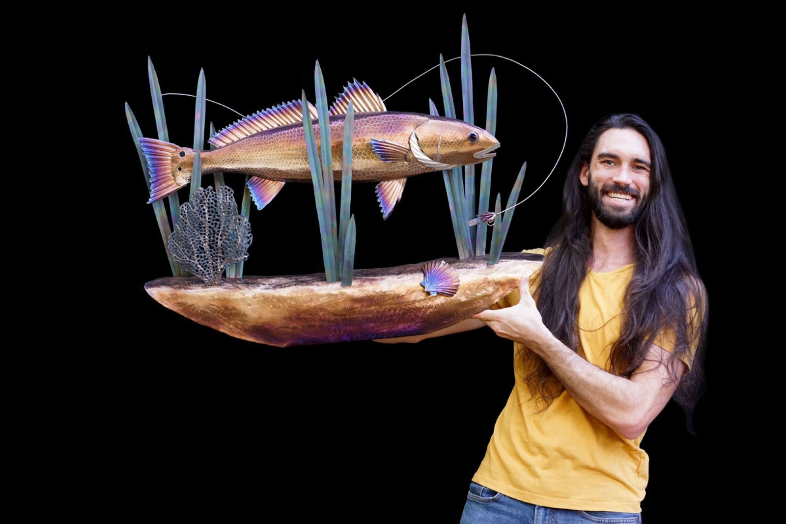 Artist Aiden Dale with his metal red drum underwater scene sculpture.