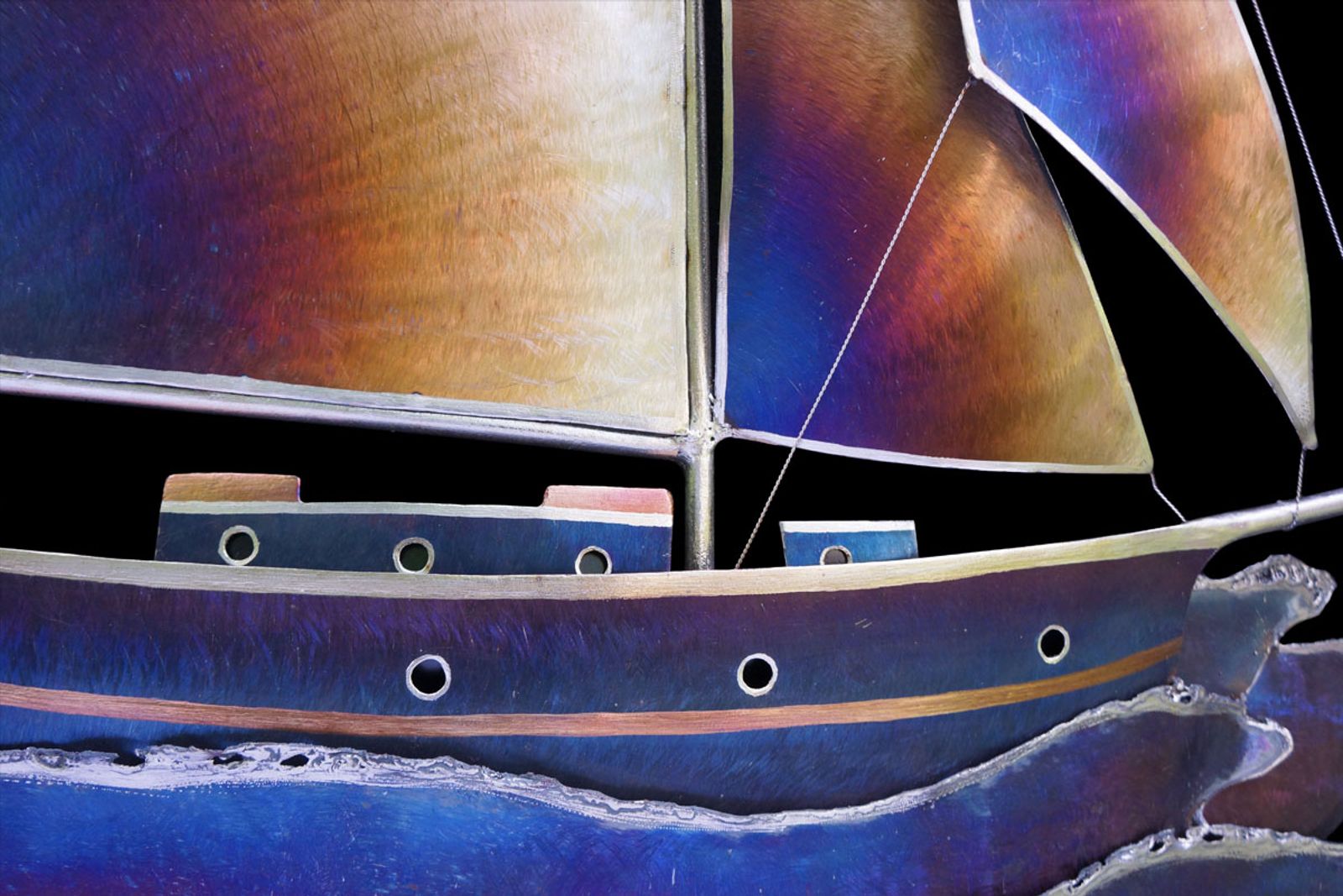 Detail of stainless steel sailboat hull with pencil-ground windows and hand-spun wire rigging twisted to resemble real rope.