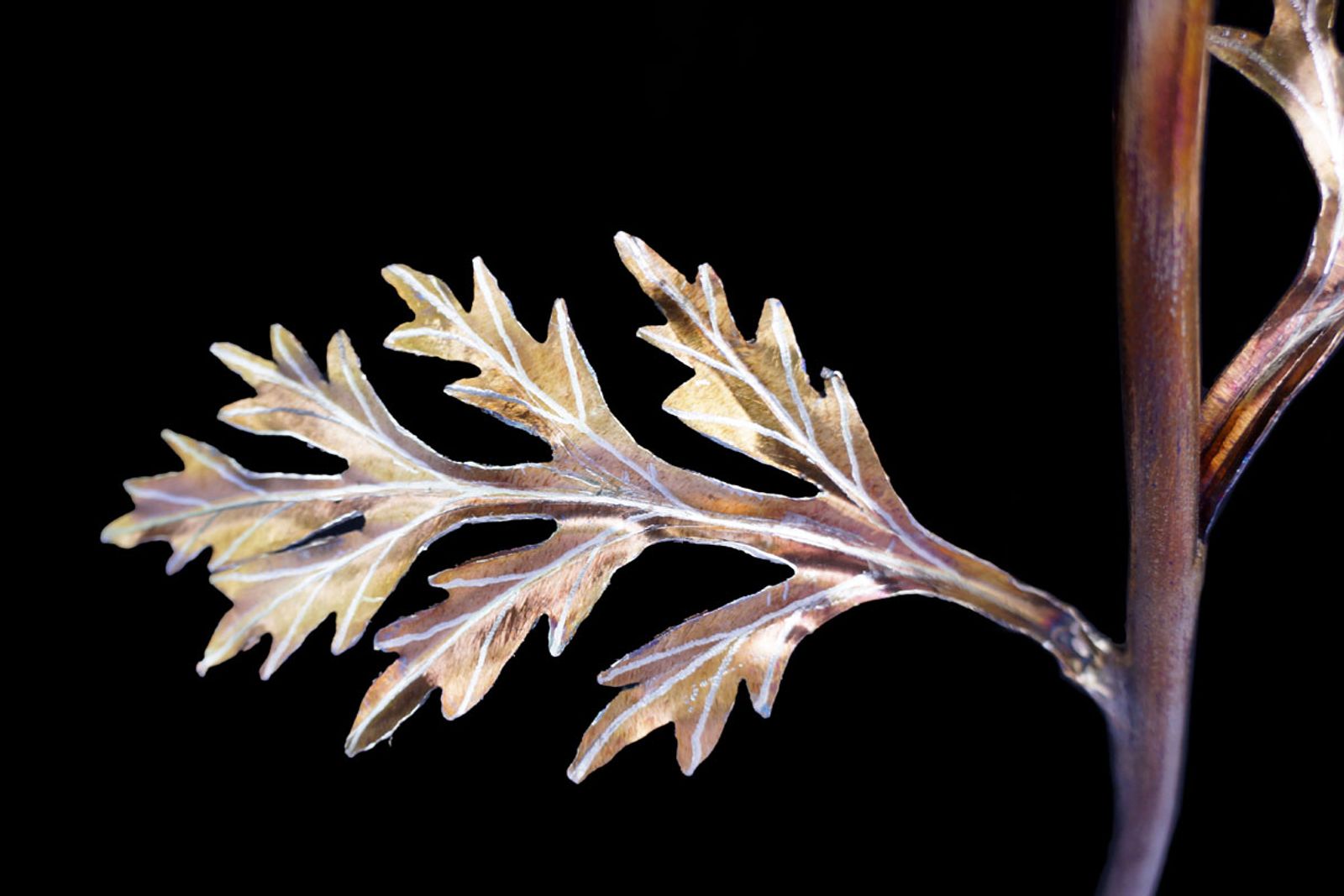 Golden stainless steel poppy leaf with hand-ground silver veins and torch patina, with bead-rolled center for lifelike detail.