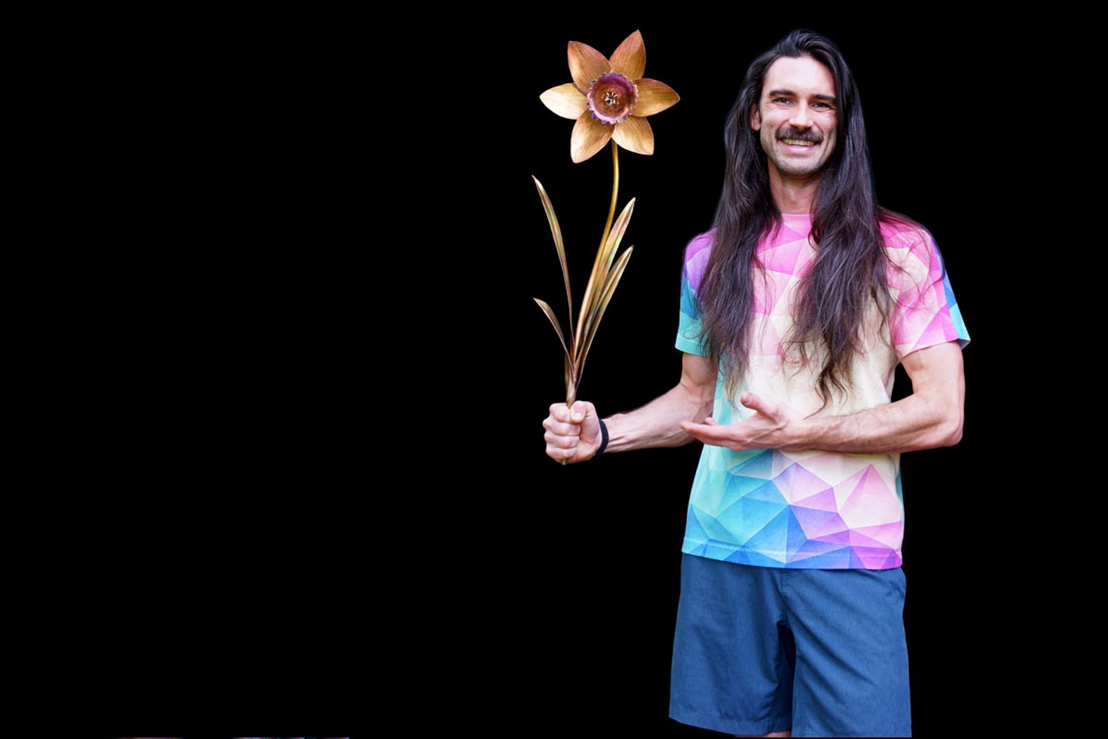 Metal sculptor Aiden Dale with his all-gold stainless steel daffodil sculpture, handmade wall art created using heat patina, not paint.