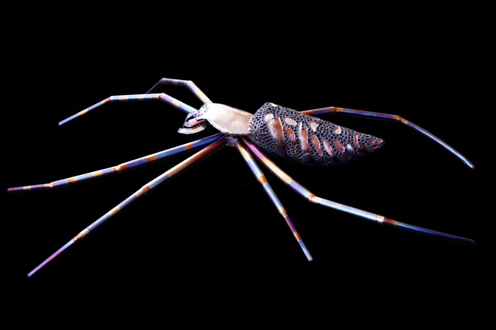 Side view of stainless steel yellow garden spider sculpture.