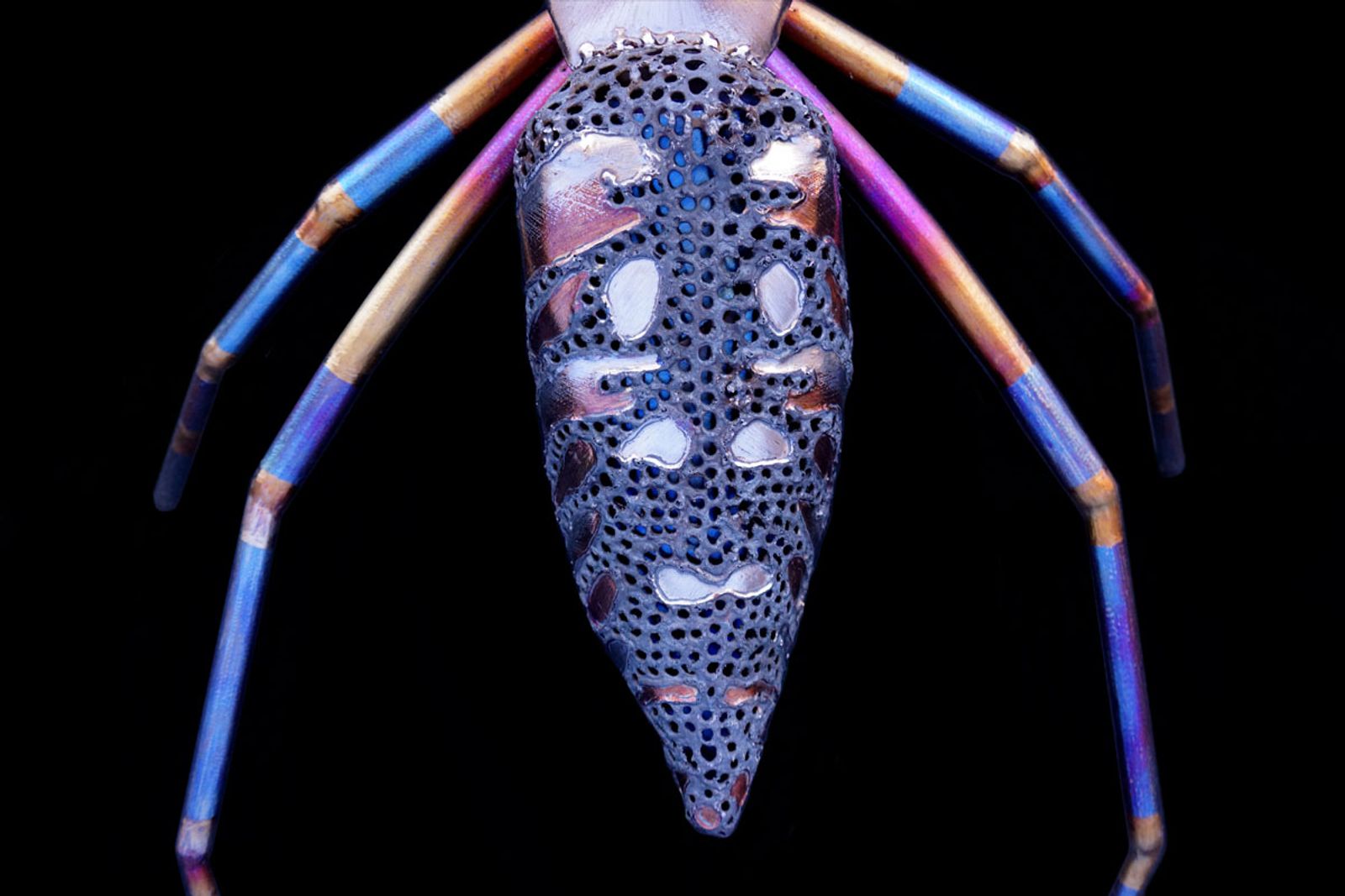 Closeup of metal orb weaver spider sculptures abdomen.