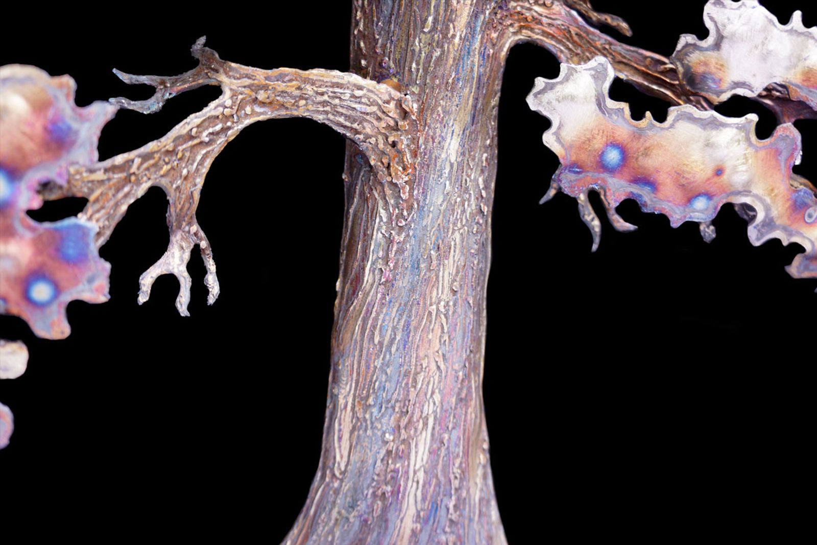 Macro view of stainless steel sequoia trunk with layered welded bark texture and torch patina for natural depth.