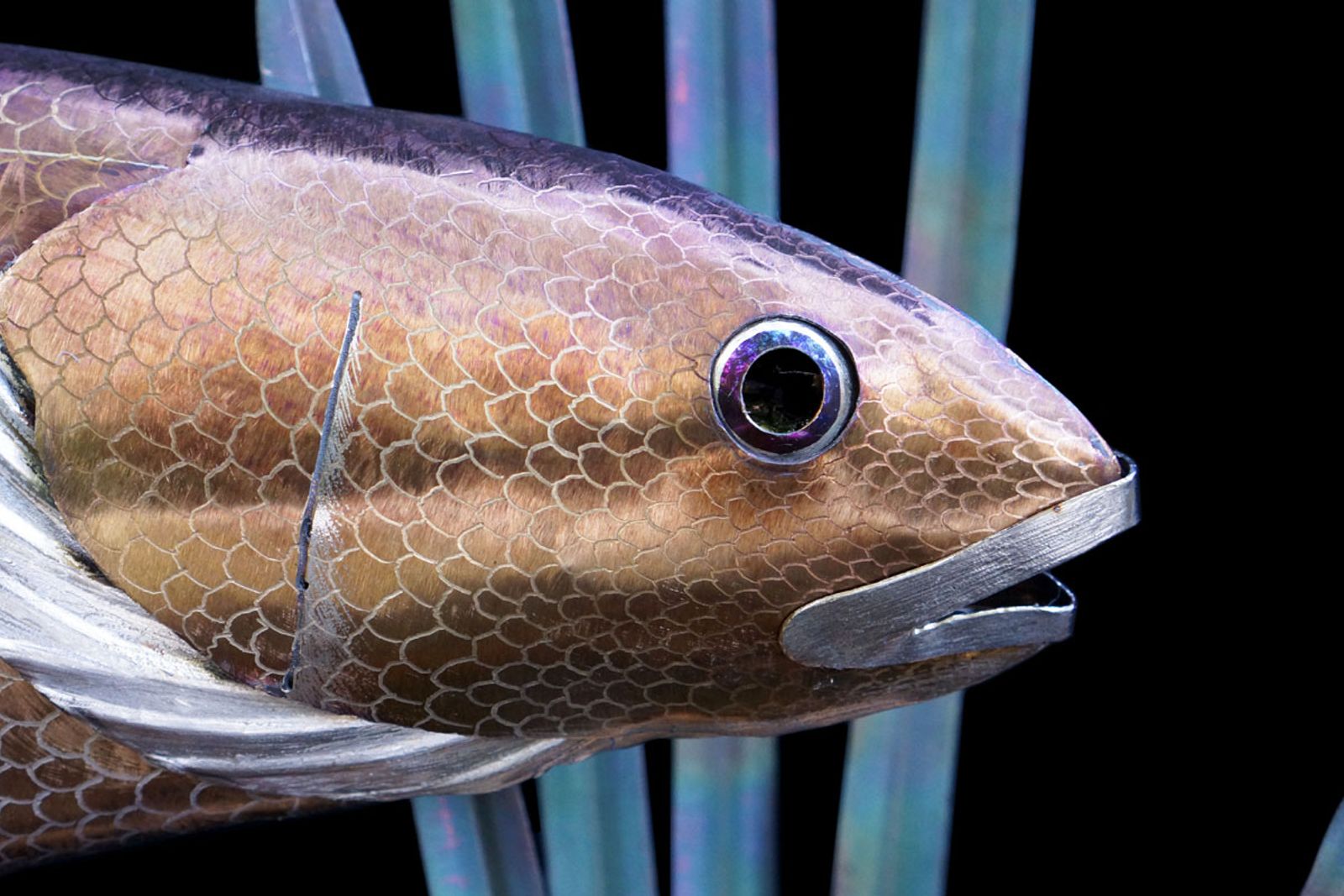 Closeup of metal red drum sculptures face.
