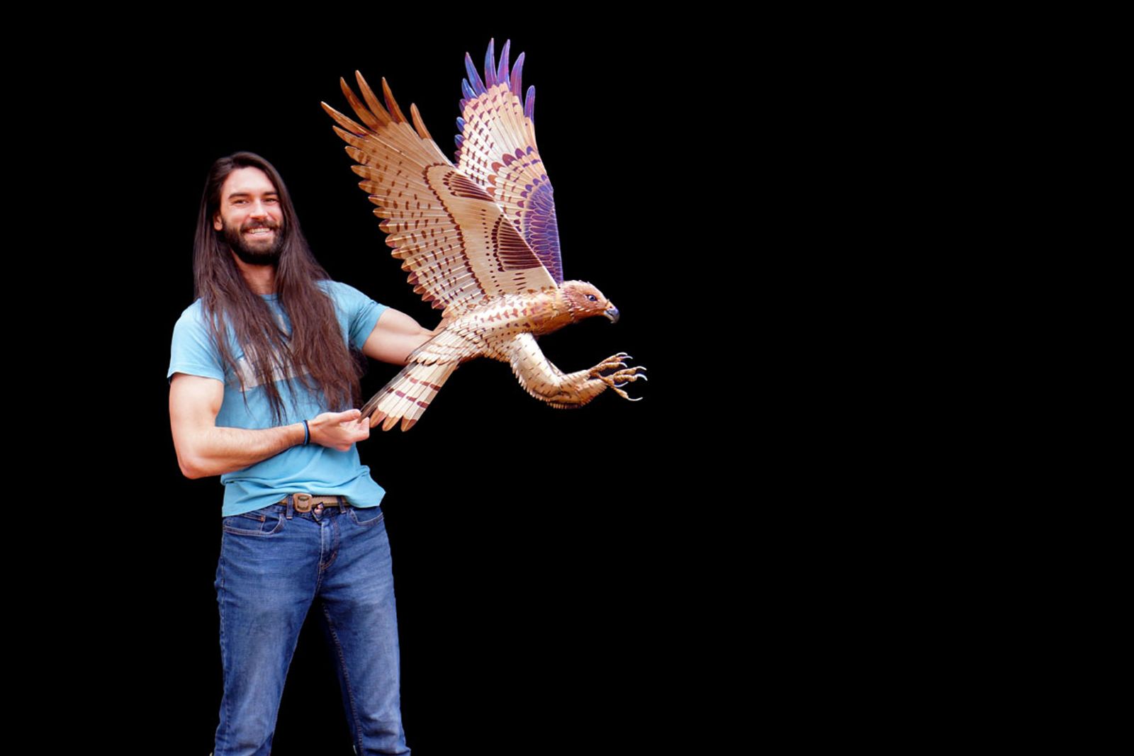 Artist Aiden Dale with metal red tailed hawk sculpture