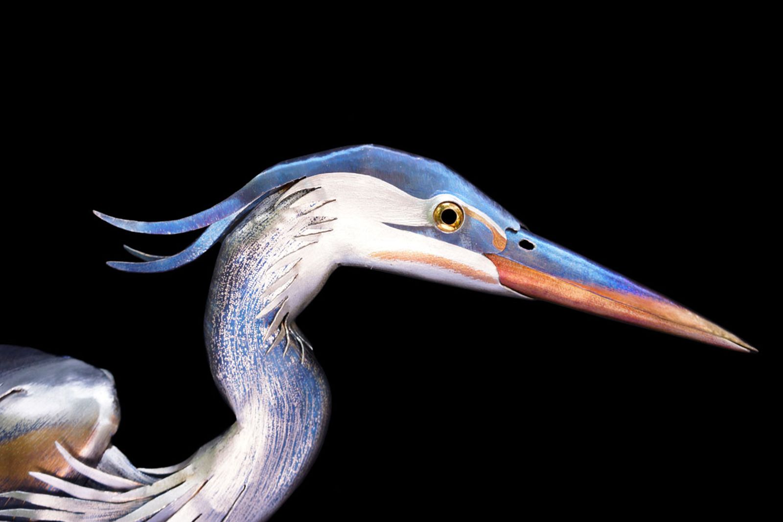 Detailed close-up of the stainless steel heron’s head, showing heat patina coloration and hand-ground feather texture