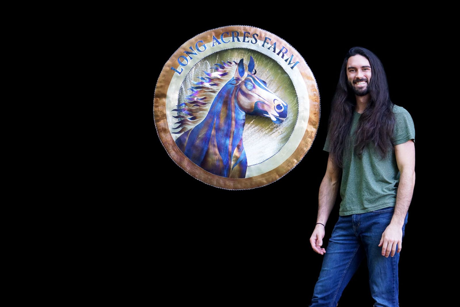 Artist Aiden Dale with stainless steel horse sign